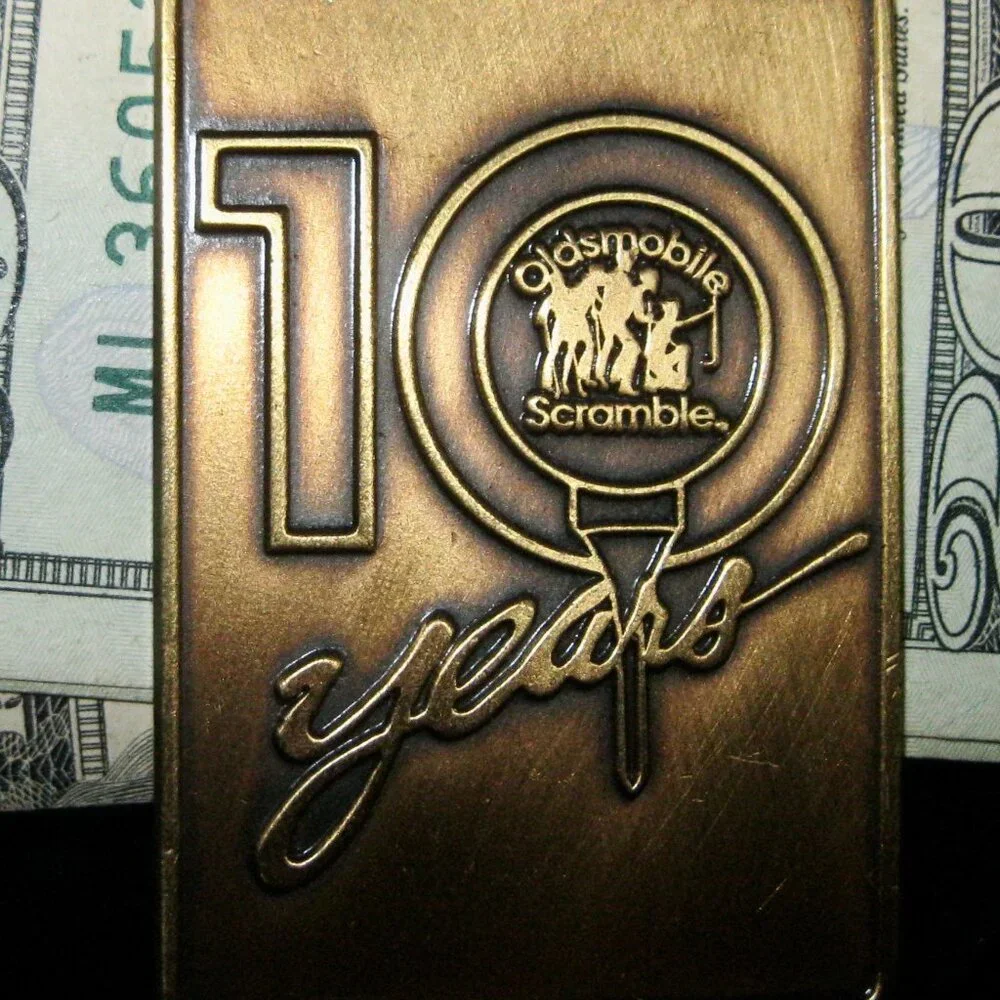 OLDSMOBILE SCRAMBLE 10 YEARS MONEY CLIP MADE IN USA 1993 (w/message on the back)